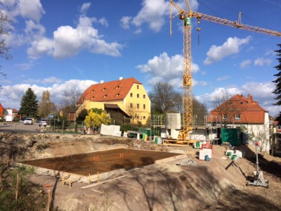 vorn Bodenplatte Doppelhaus, dahinter Einfamilienhaus