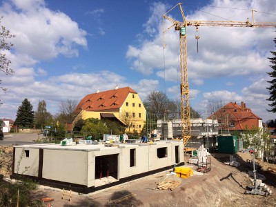 vorn Keller aus Stahlbeton Doppelhaus, dahinter Rohbauarbeiten Einfamilienhaus